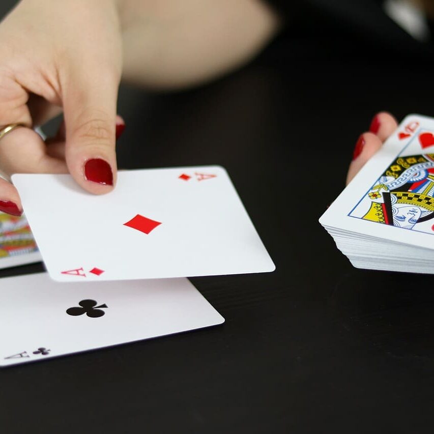 A woman is playing cards on the table